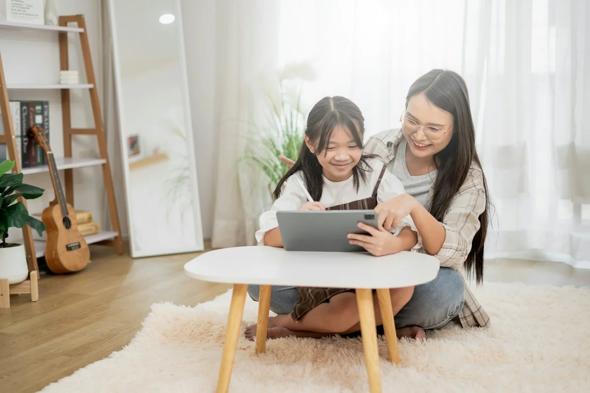 A mother and daughter sharing a happy moment with a tablet at home